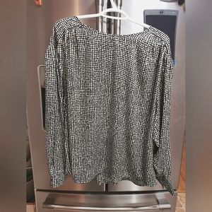 Black and white blouse with button closure on back and on cuffs.